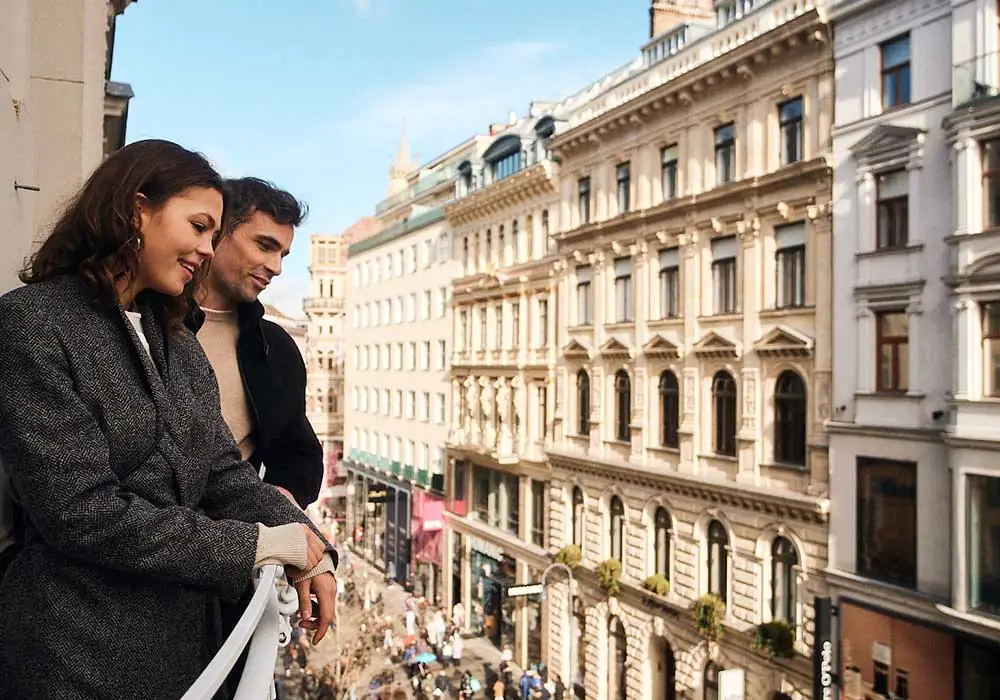 Couple enjoying city view from balcony.